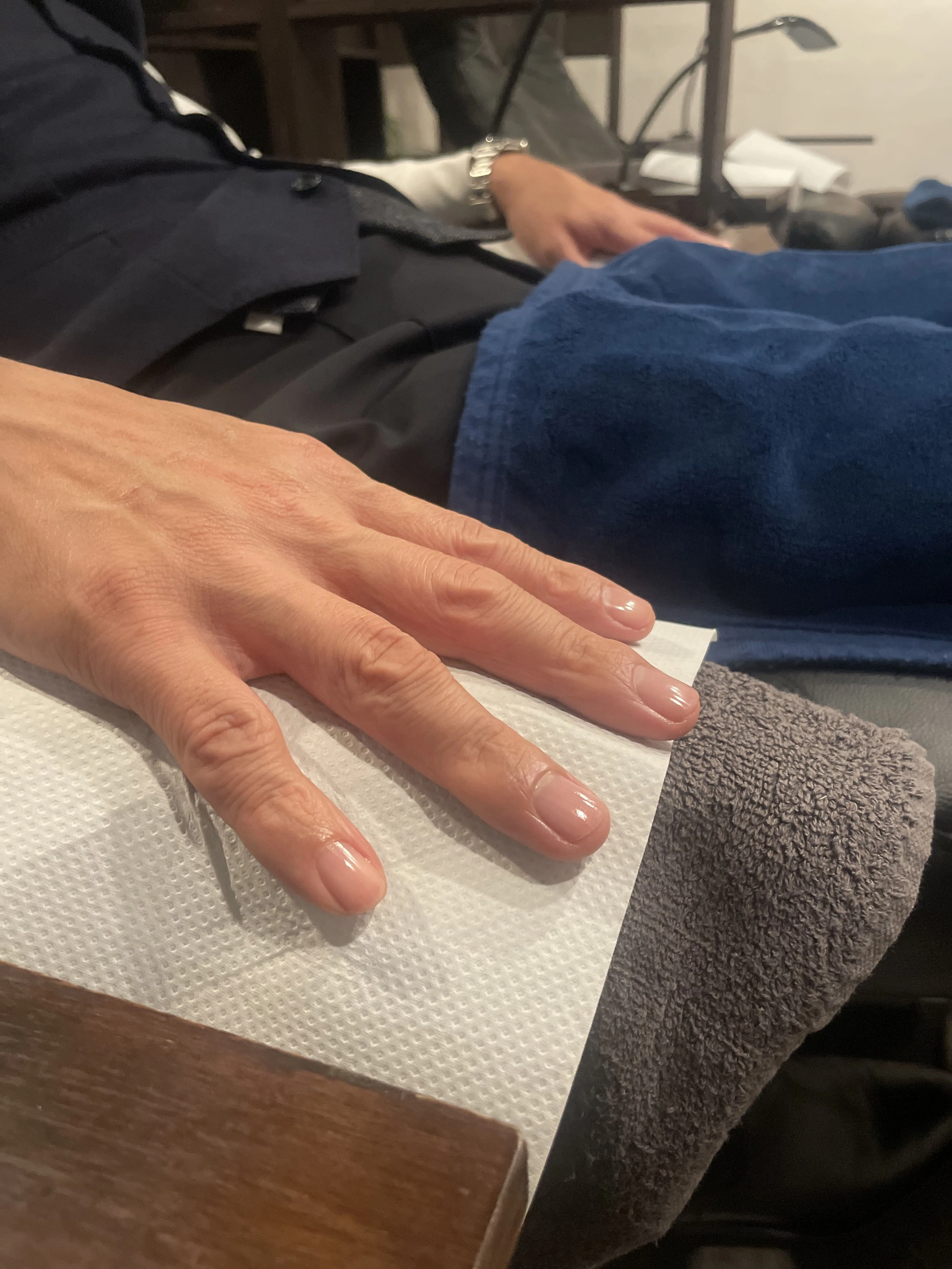 ネイルが終わり、仕上げをされている男性の手