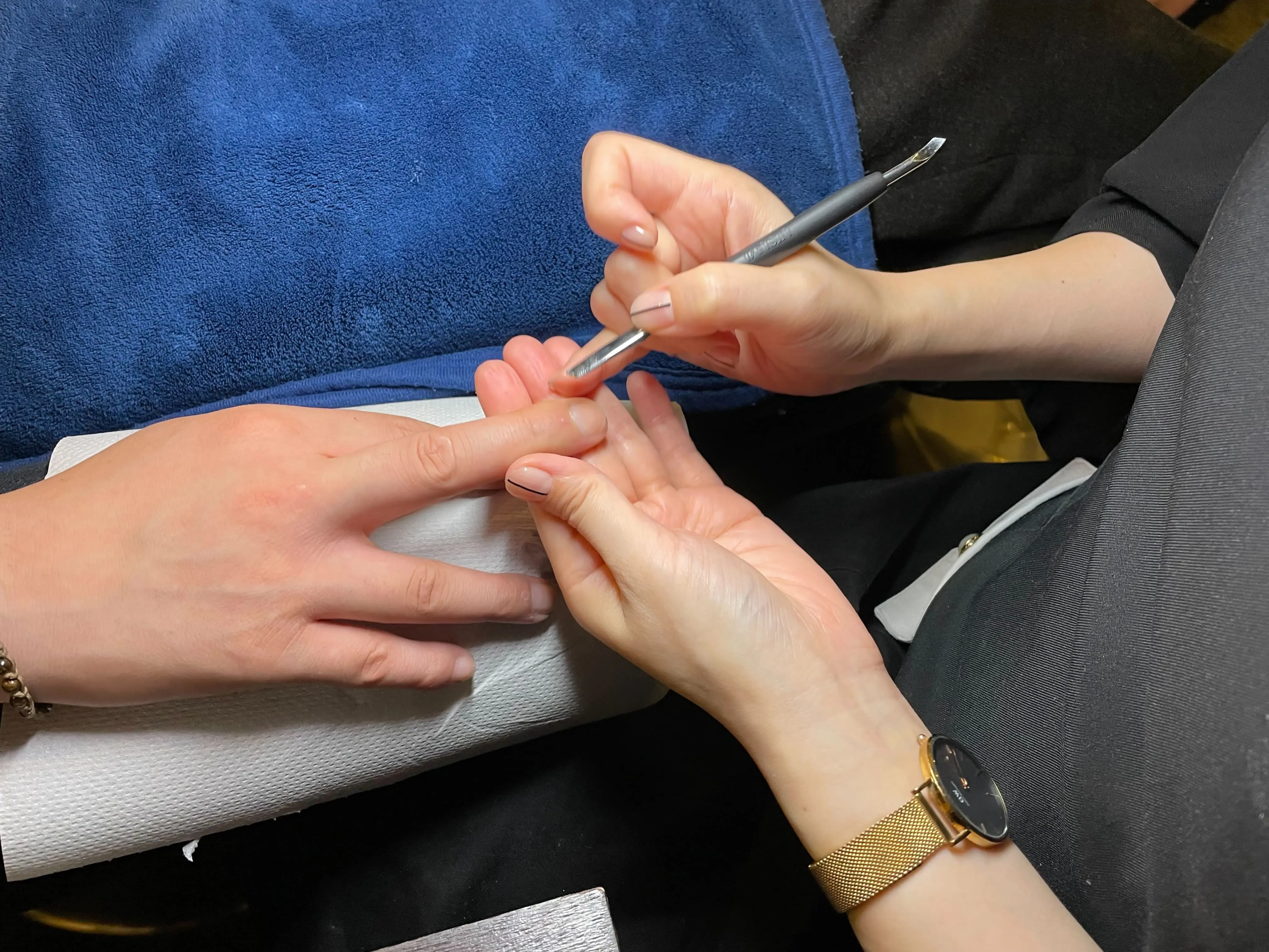 プッシャーを使って甘皮を押し上げている施術中の手元で、繊細なケアが行われている